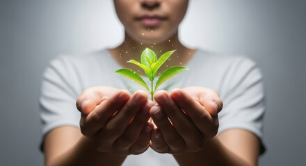 Asian woman gently cradles a small green plant in her hands, symbolizing growth and sustainability, with a soft glowing light illuminating the scene