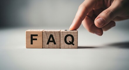 Naklejka premium Close up of a finger touching wooden blocks spelling out faq