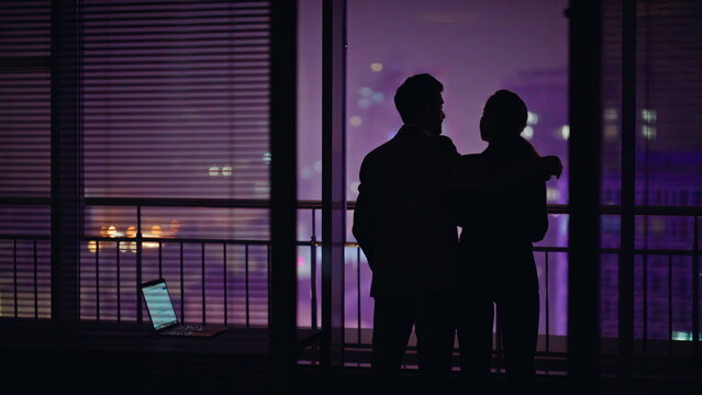 Love couple dark silhouettes looking cityscape rear view. Unknown romantic pair - Powered by Adobe
