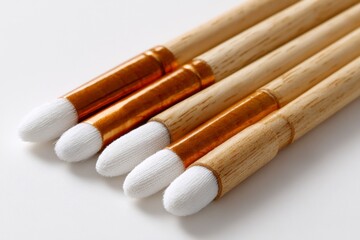 Closeup of five art brushes with wooden handles and white tips