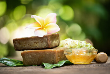 Noni fruits extracted and honey used to make soap on natural background.