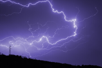 Lightning storm in the night sky during a thunderstorm. Dramatic lightning strike through dark storm.