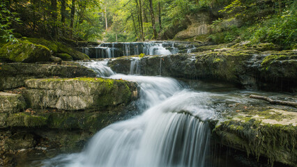 les cascades du hérisson dans le Jura en été, un magnifique torrent serpentant entre la forêt verdoyante