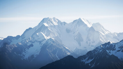 Majestic Snow-Capped Mountain Range Under Soft, Atmospheric Blue Sky