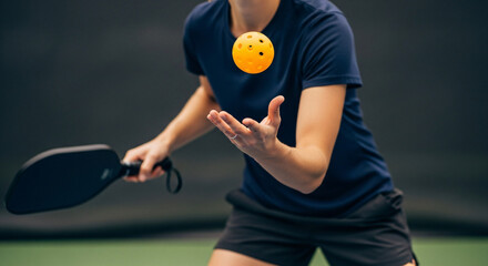 Three wooden pickleball paddles serving as trophies stand proudly behind a collection of various medals awarded at a sporting event.
