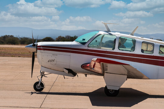 small plane taking off the runway airport strip, blue sky and bush in the back, african aviation - Powered by Adobe