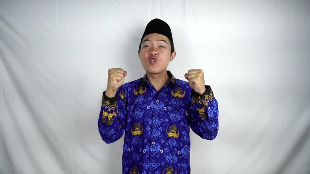 An excited male Indonesian civil servant wearing a Korpri uniform poses with a happy and successful expression. Civil servant concept.