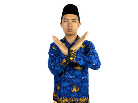 Serious government worker man wearing blue batik uniform with hand gesture pose rejection or prohibition. PNS civil servant concept.