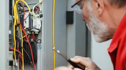 Retired electrician works on electrical panel repairs
