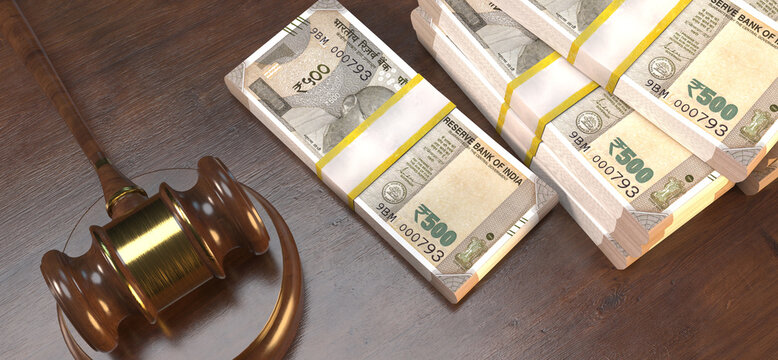 An image showing a judge's gavel next to stacks of Indian five hundred rupee notes on a wooden table.