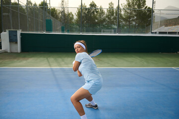 Focused Female Tennis Player Preparing to Return a Shot on Outdoor Court