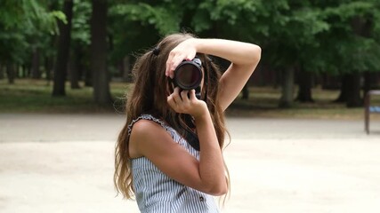 Girl learning to take photos. Kid photographer in city park. Young person making images with professional camera
