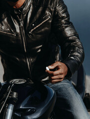 Fototapeta premium A man sits on a bike, holding a white pill in his hand. Concept of men’s health and strength. 
