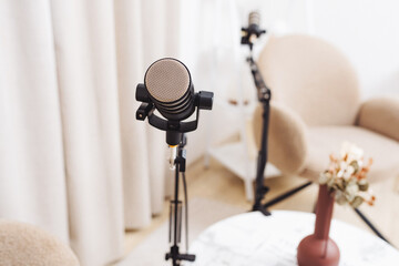 Podcast setup featuring a microphone ready for interview in a cozy room with soft chairs
