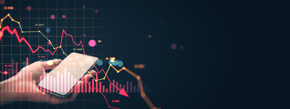 Businessman holding smartphone with falling stock graph showing financial crisis and global market crash on dark background. - Powered by Adobe