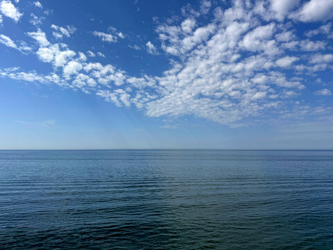 Blue sky with clouds and blue calm sea.