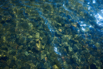 Clear Water with Stones and Sun Glare on Lake