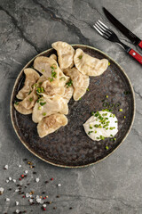 Close-up of traditional Ukrainian dumplings filled with mashed potatoes and served with sour cream. Authentic Eastern European cuisine and comfort food.
