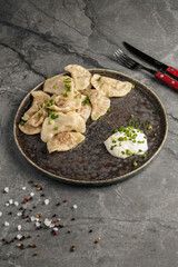 Close-up of traditional Ukrainian dumplings filled with mashed potatoes and served with sour cream. Authentic Eastern European cuisine and comfort food.