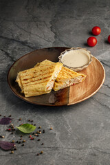 Delicious chicken roll served with fresh vegetables and flavorful sauce on a plate. Tasty tortilla wrap filled with juicy grilled chicken, lettuce, tomato, cucumber, and creamy dressing. Close-up of a
