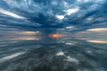 Fototapeta premium Sunset over dark water, soft focus. Ocean horizon, dramatic colors