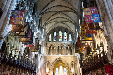 Interior of St Patricks Cathedral in Dublin Ireland with vaulted ceilings and colorful flags decorating the historic church