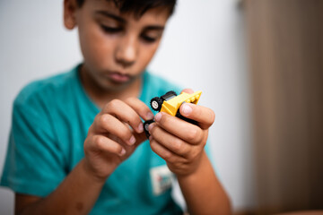 Concentrated child playing with construction toy truck at home