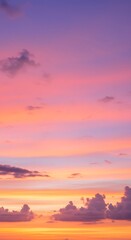 Obraz premium A vibrant sunset sky displays a gradient of colors from orange to pink to purple, with scattered clouds.
