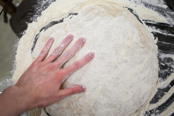 Making Fresh Yeast Dough by Hand with Flour on Kitchen Table, Close Up Process