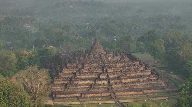 Aerial drone view fly orbiting around Borobudur temple at sunrise, Indonesia 