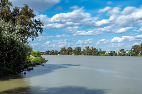 Calm waters reflect the sky over Guadalquivir in Coria del Rio