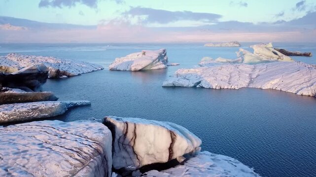 Aerial view flying pass over icebergs in Jokulsarlon glacier lagoon, Iceland 