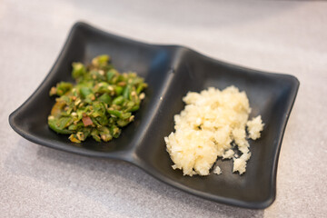 Shredded garlic and shredded chilli on black bowl for add sukiyaki sauce