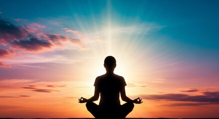 Silhouette of a person meditating in lotus pose with a radiant light beam rising from their head against a colorful sunset sky.