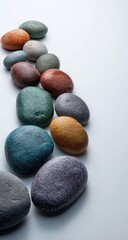 Colorful stones in a gentle curve against a plain white background