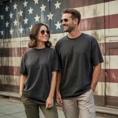 Fototapeta premium Middle-aged couple, male and female models wearing black crewneck t-shirt, cargo pants standing beside American flag. Women's, men's short sleeve tshirt mockup. Proud army mom, dad 