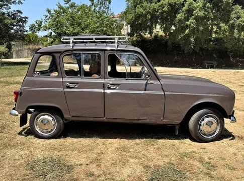 Renault 4L parking in a field with roof rack ready for vacation