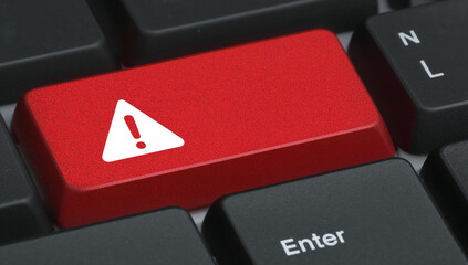 Red warning key on black computer keyboard close-up view  