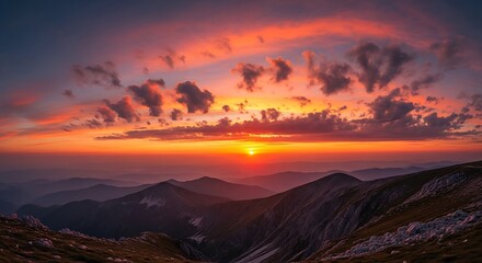 Fototapeta premium Majestic sunset paints the sky over mountain range.