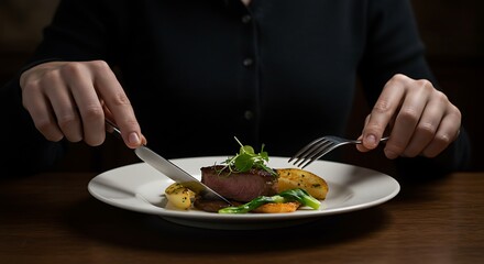 Elegant close-up of a person enjoying a beautifully plated gourmet food dish, expertly cutting a meal with a knife and fork in a refined dining setting, highlighting the art of eating