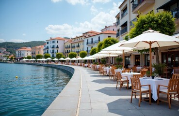 Fototapeta premium Outdoor waterfront restaurant with tables, chairs, and umbrellas along a scenic canal or river in a coastal town