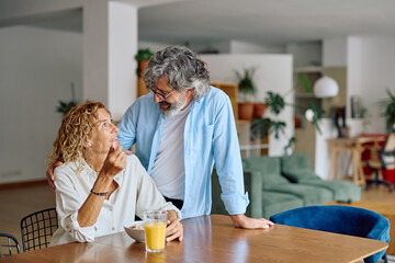 Senior couple enjoying a loving breakfast together in their bright, modern kitchen, sharing smiles and conversation over healthy food