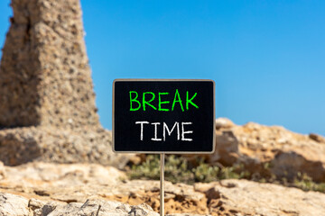 Break time symbol. Concept word Break time on beautiful black blackboard. Beautiful stone and blue sky background. Black blackboard. Business break time concept. Copy space.