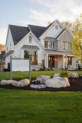 A contemporary residential home features an elegant stone facade, surrounded by vibrant landscaping, all beautifully illuminated during the golden hour in a charming suburban neighborhood