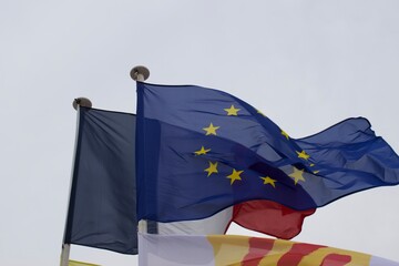 Drapeaux de l'Union europ&eacute;enne et de la France flottant ensemble lors d'un &eacute;v&eacute;nement sur la place publique