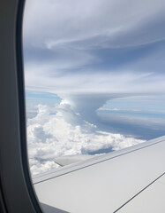 Obraz premium View from the airplane window at a beautiful cloudy sky and the airplane wing. isolated with white highlights