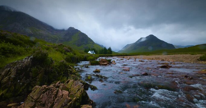 Wee White House in den schottischen Highlands, bl&uuml;hende Heidestr&auml;ucher am Bachufer, dramatisch bew&ouml;lkter Himmel und drohendes Unwetter in stimmungsvoller Naturaufnahme