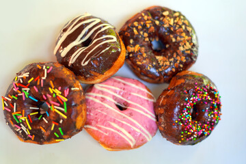 Sweet Donuts with Pink and Chocolate Toppings on White Background.