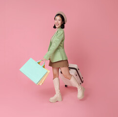 Happy Asian woman carrying shopping bags and suitcase stylish outfit and cheerful expression symbolizing travel tourism shopping lifestyle retail consumerism and modern leisure concept
