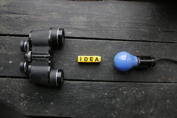 Idea concept. Blue Light lamp and vintage binoculars.